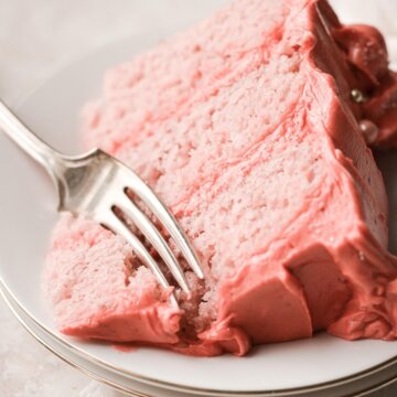 Slice of strawberry cake with a bite cut.