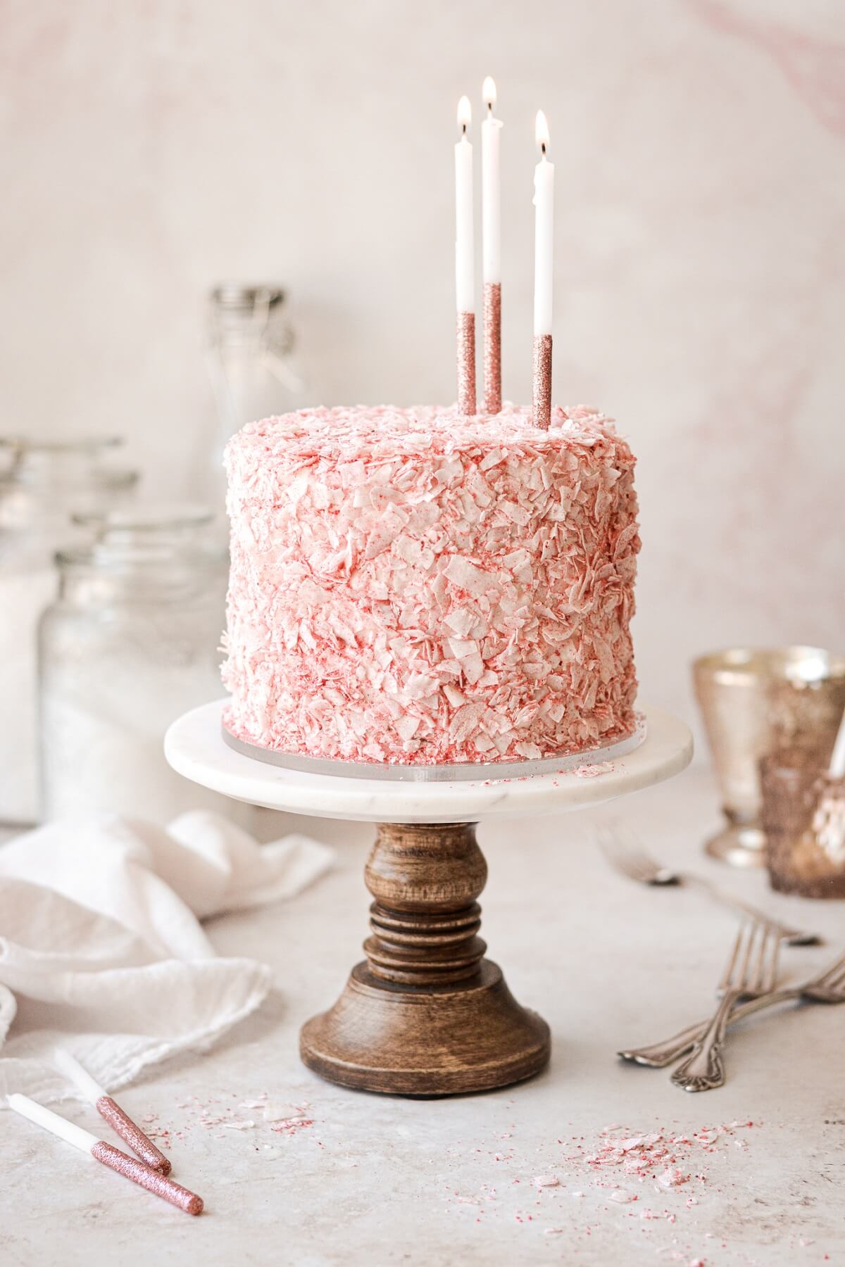 Strawberry coconut cake with pink and white candles.