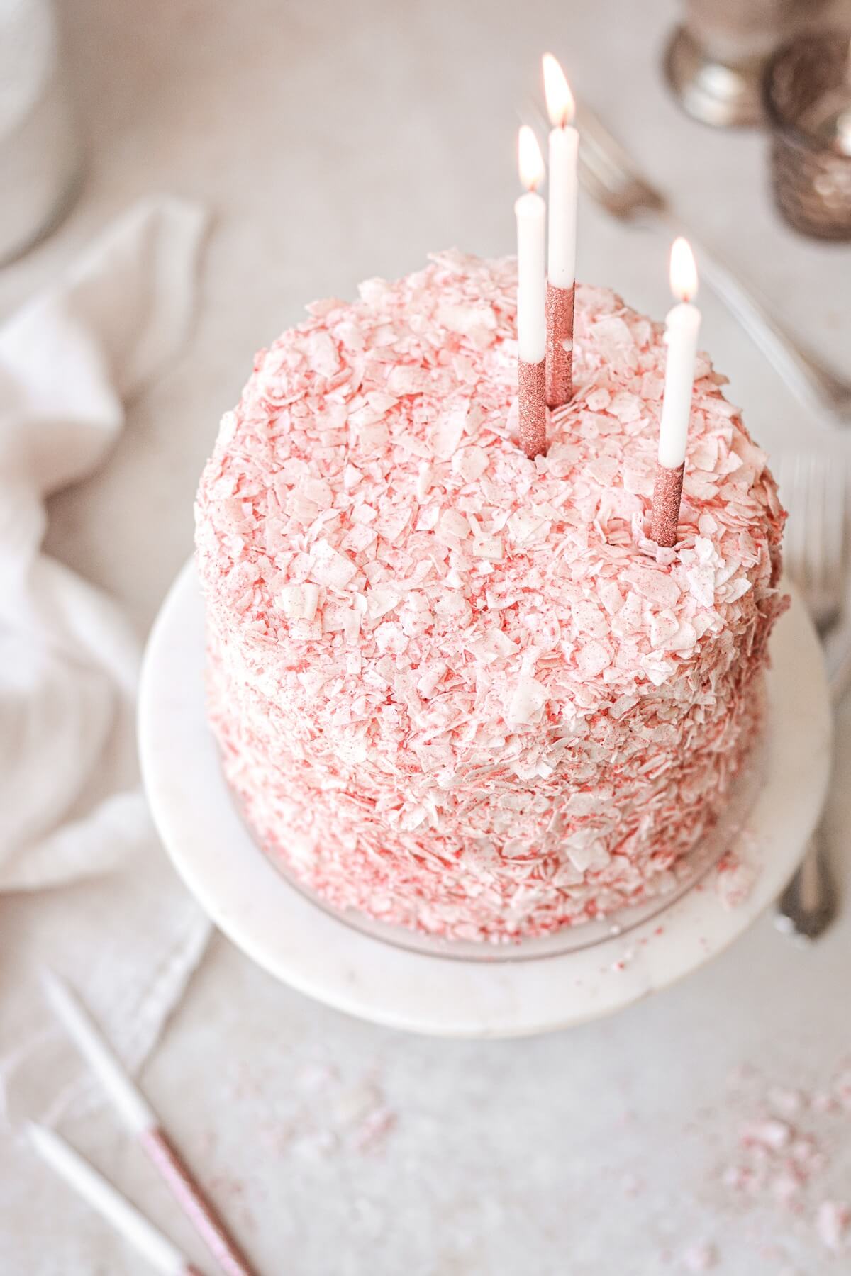 Strawberry coconut cake with birthday candles.