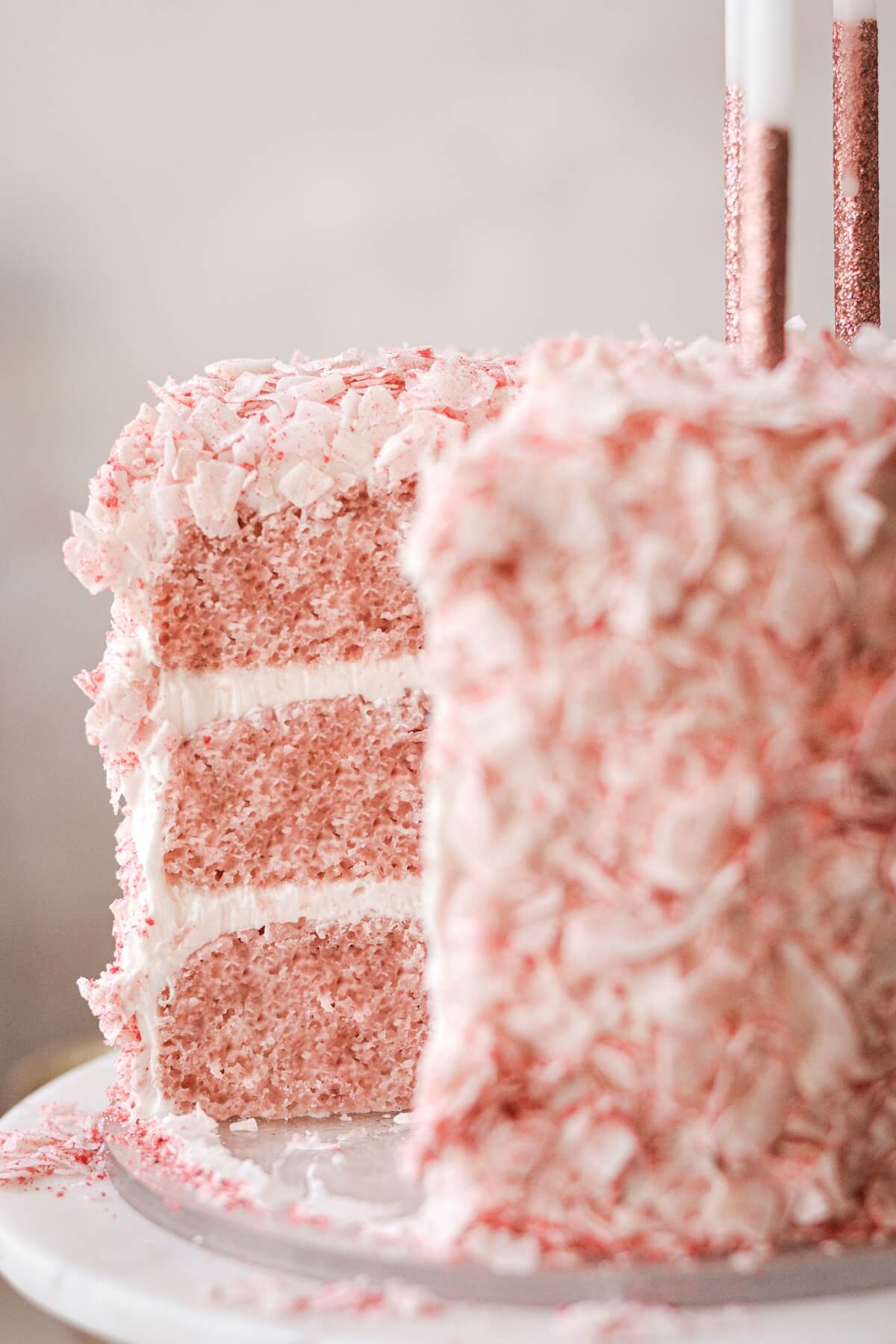 Strawberry coconut cake with a slice cut.