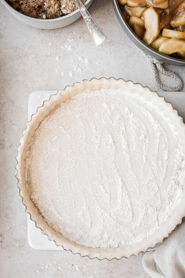 Flour sprinkled into a pie crust.