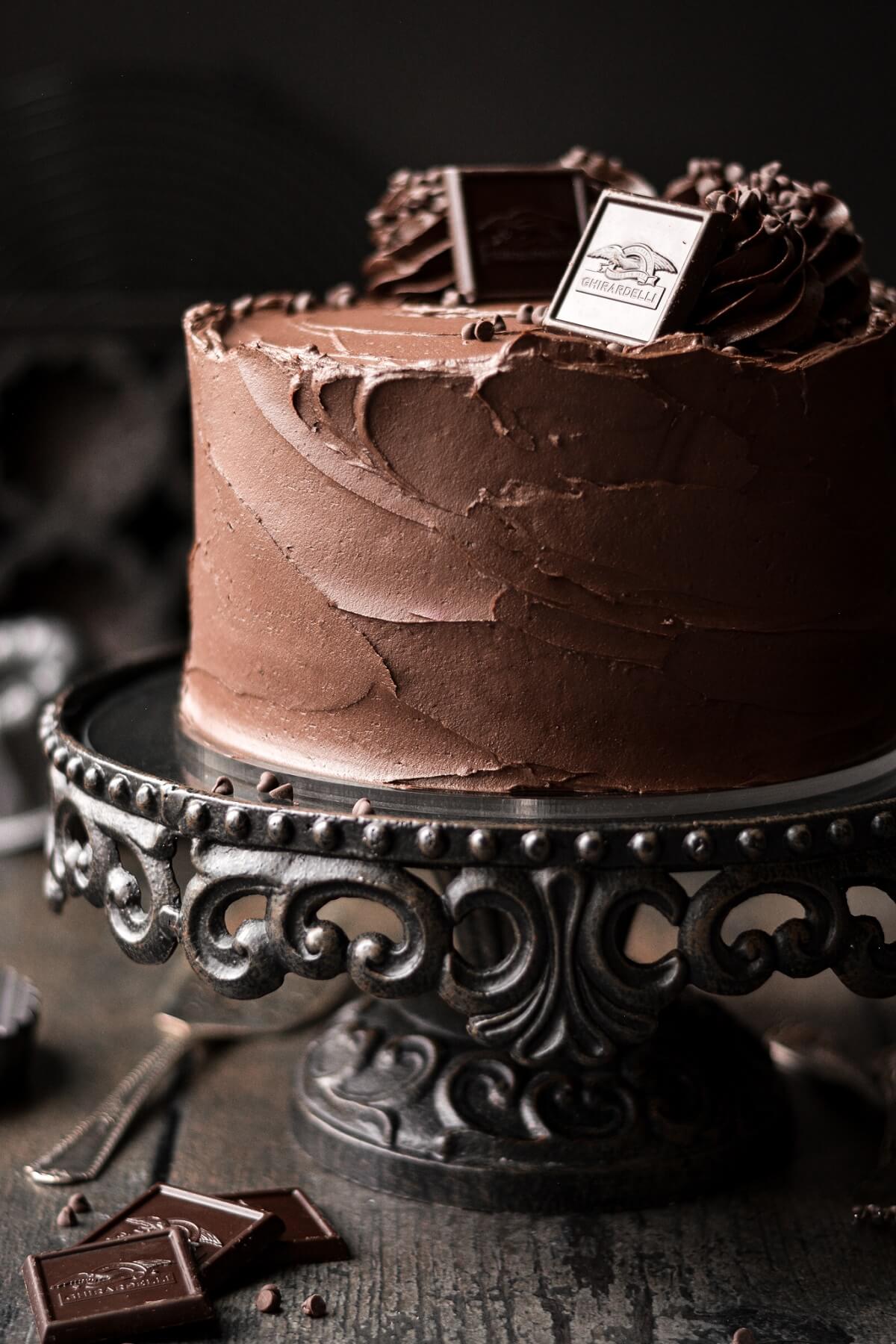 Chocolate cake on a black cake stand.