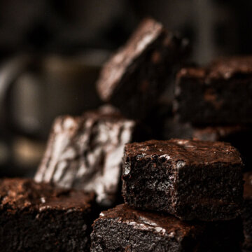 Thick high altitude fudge brownies, one with a bite taken.