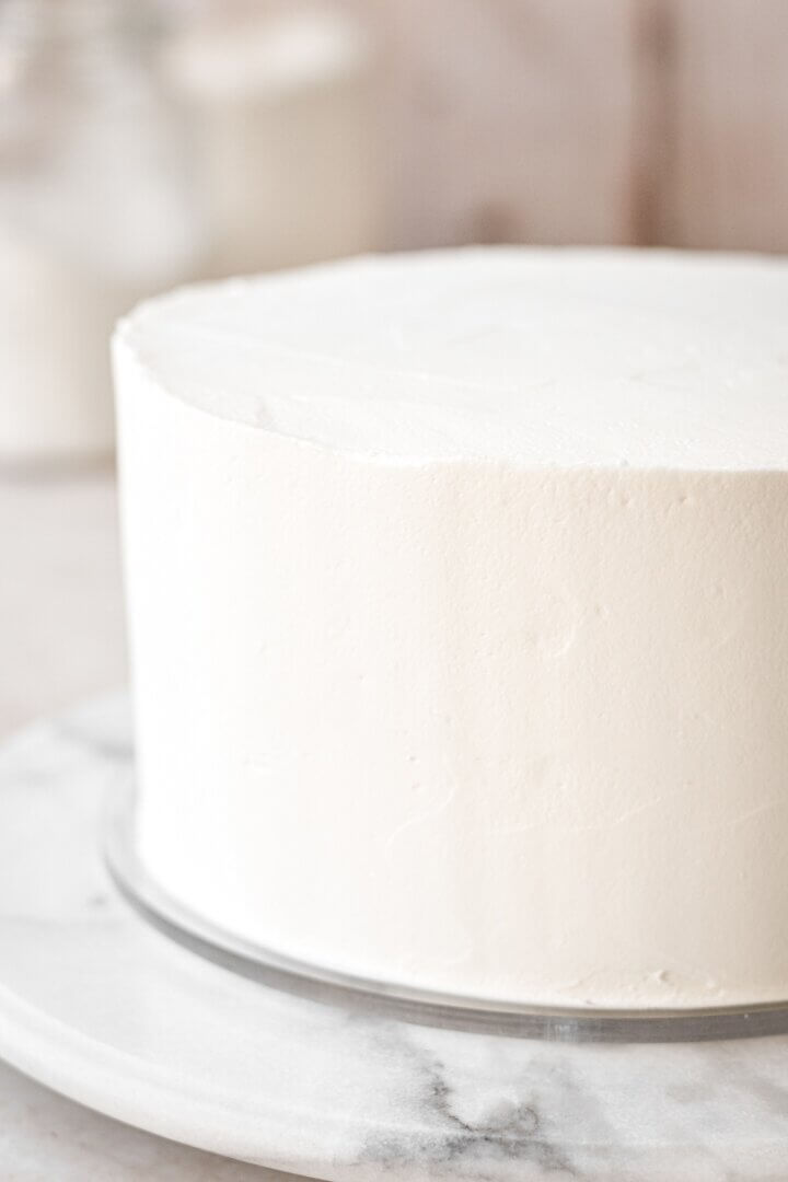 Cake frosted with a smooth coat of vanilla buttercream.