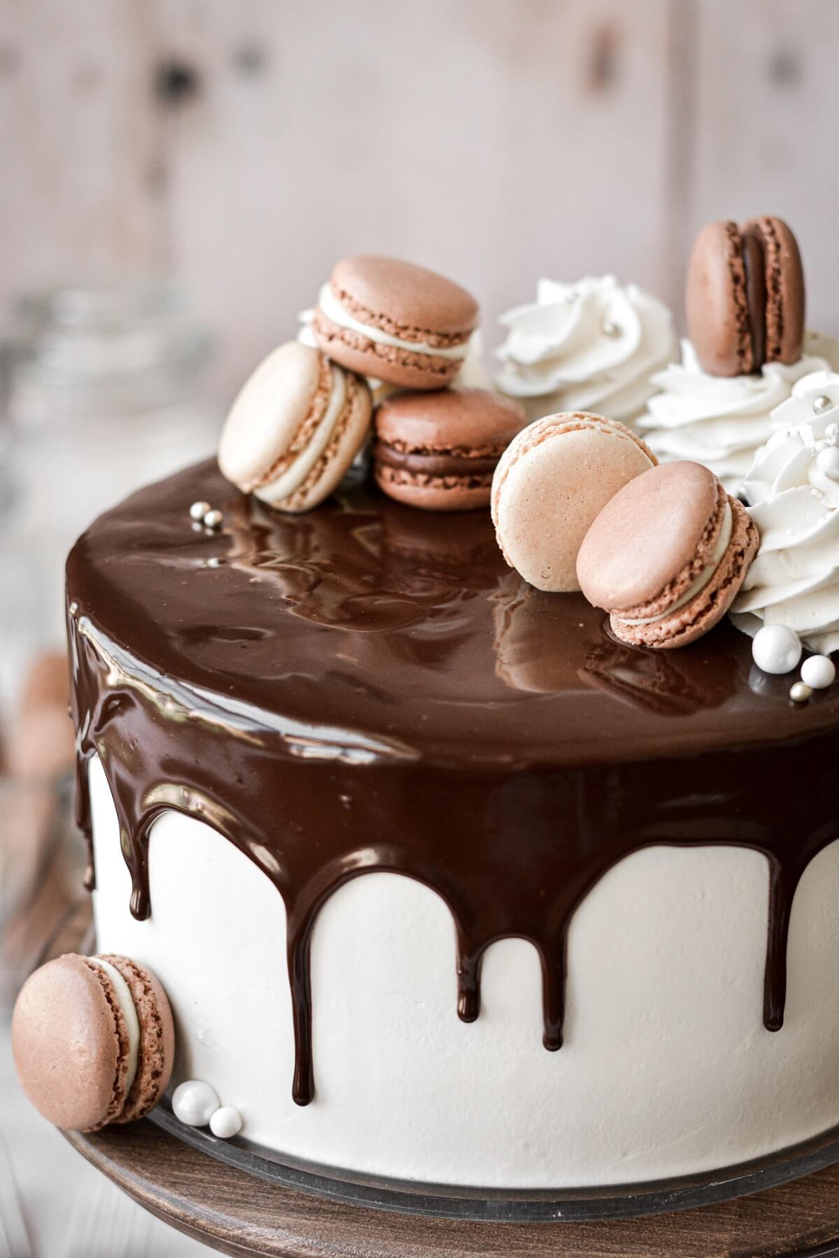 Macarons and chocolate drip on a marble cake.