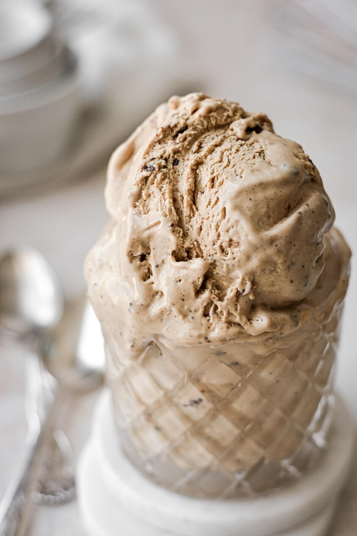 Peanut butter mocha chip ice cream melting down the side of a glass.
