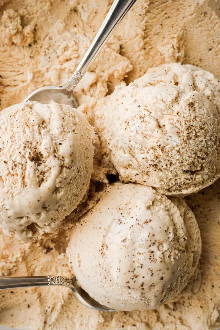 Scoops of no churn pumpkin ice cream sprinkled with ground vanilla bean.