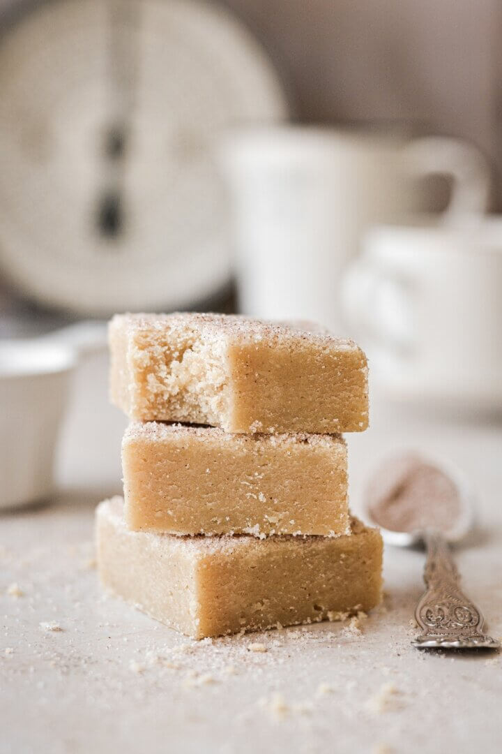 Stack of snickerdoodle blondies, one with a bite taken.