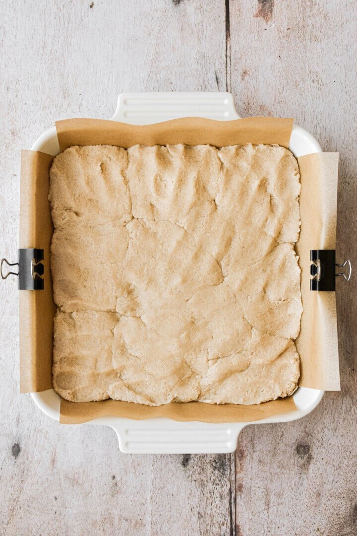 Snickerdoodle cookie dough pressed into a baking pan.