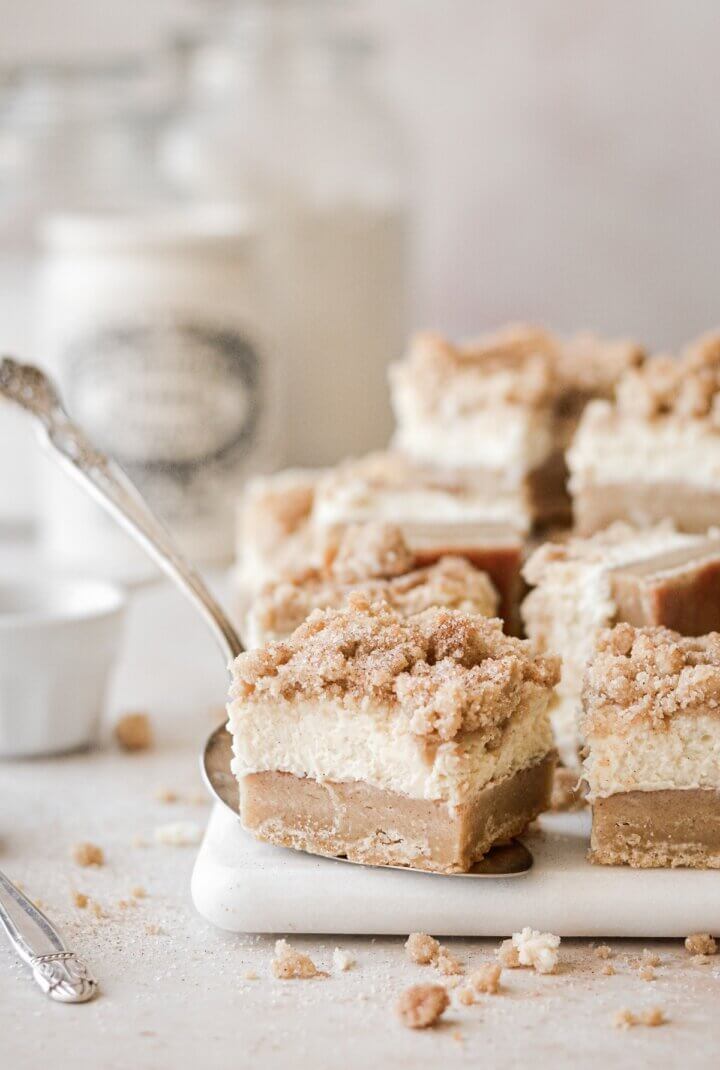 Snickerdoodle cheesecake bars on a marble board.