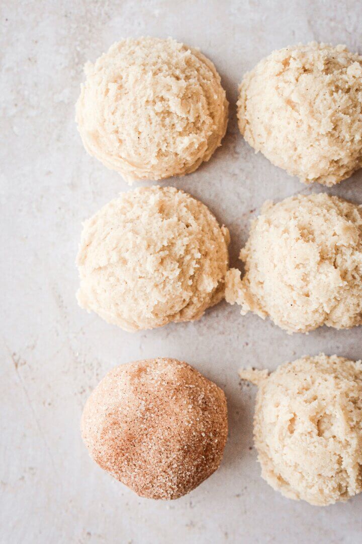 Snickerdoodle dough balls coated in cinnamon sugar.