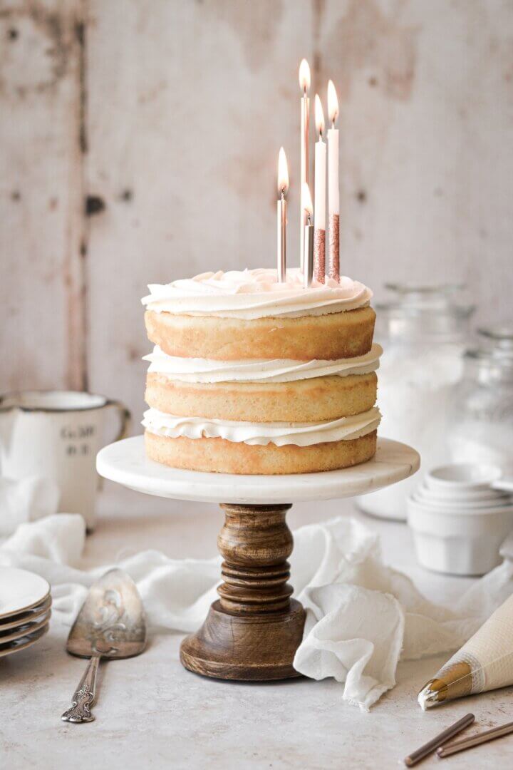 Naked vanilla cake with birthday candles.