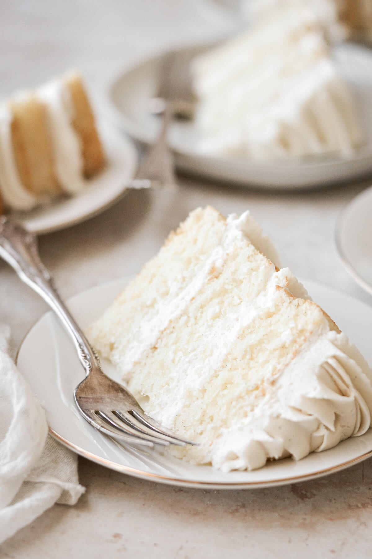 Slice of vanilla cake with a silver fork.