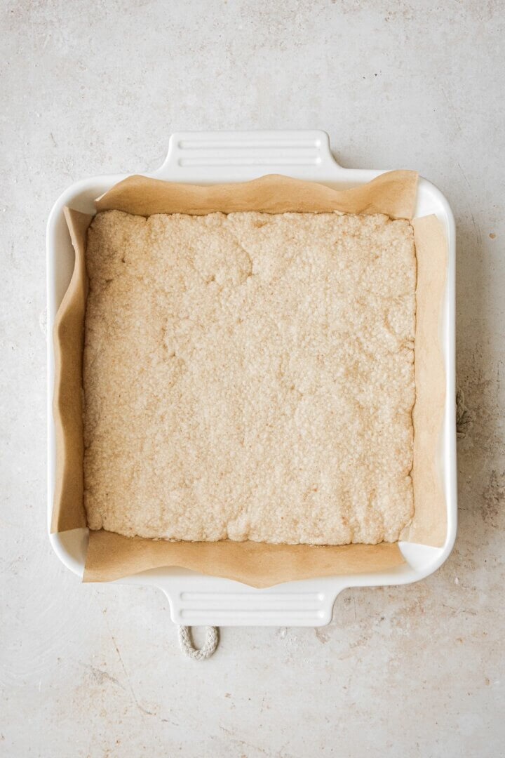 Square pan with a baked crust on the bottom.