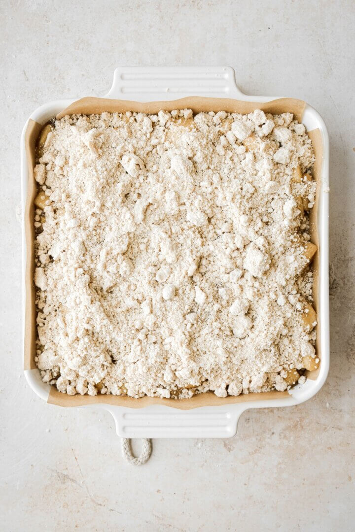 Crumb topping sprinkled over apple bars.