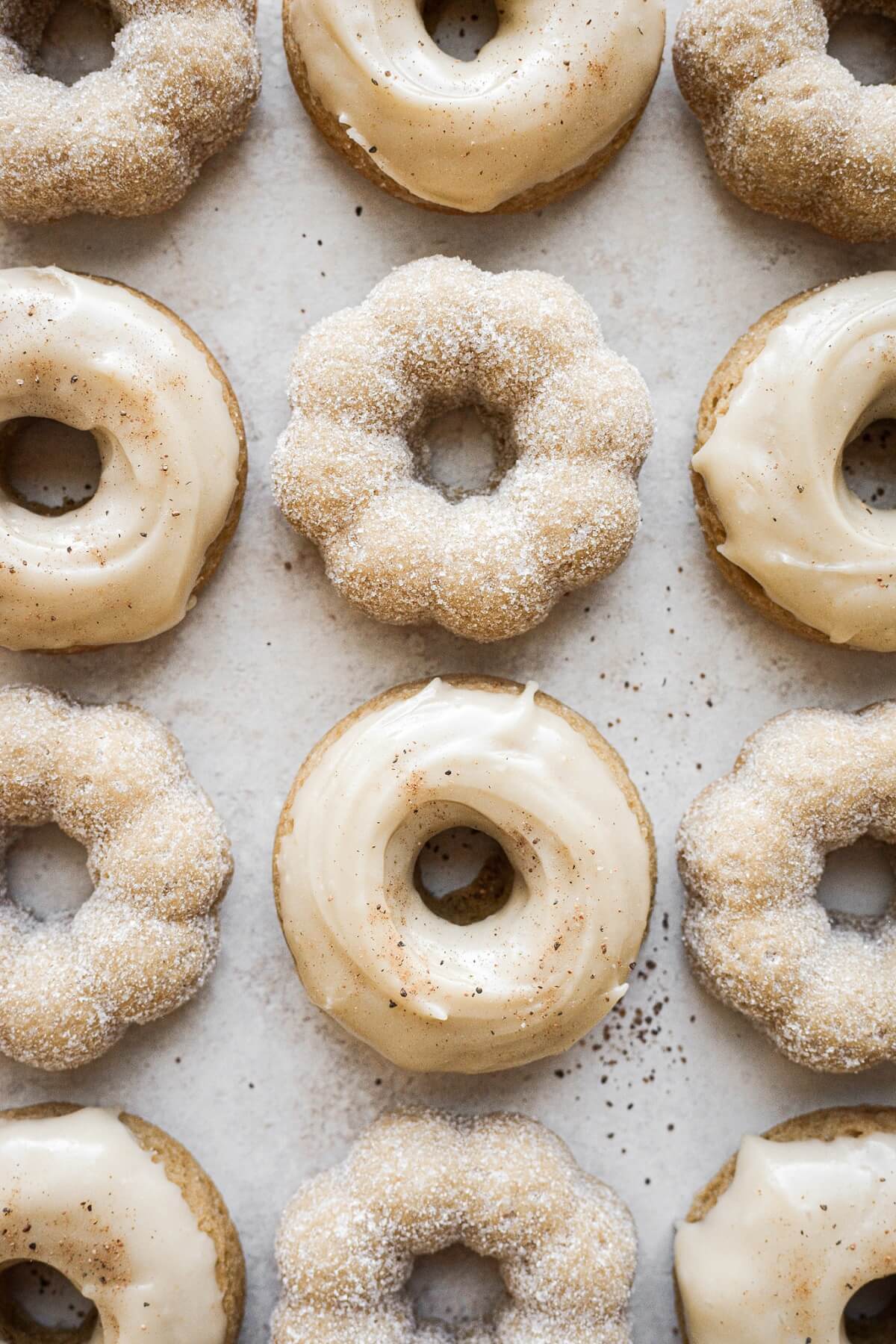 Baked maple donuts coated in sugar and topped with maple icing.