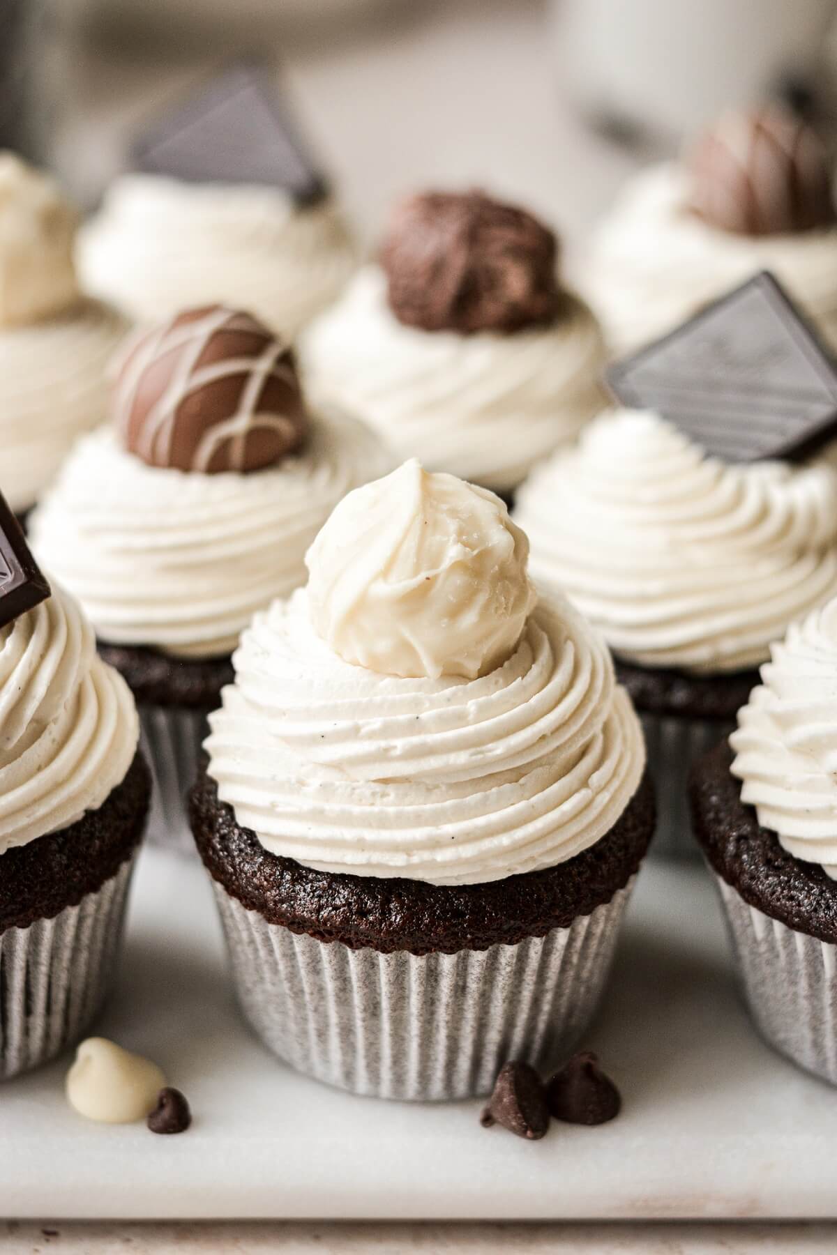 Chocolate truffles on top of black and white chocolate cupcakes.