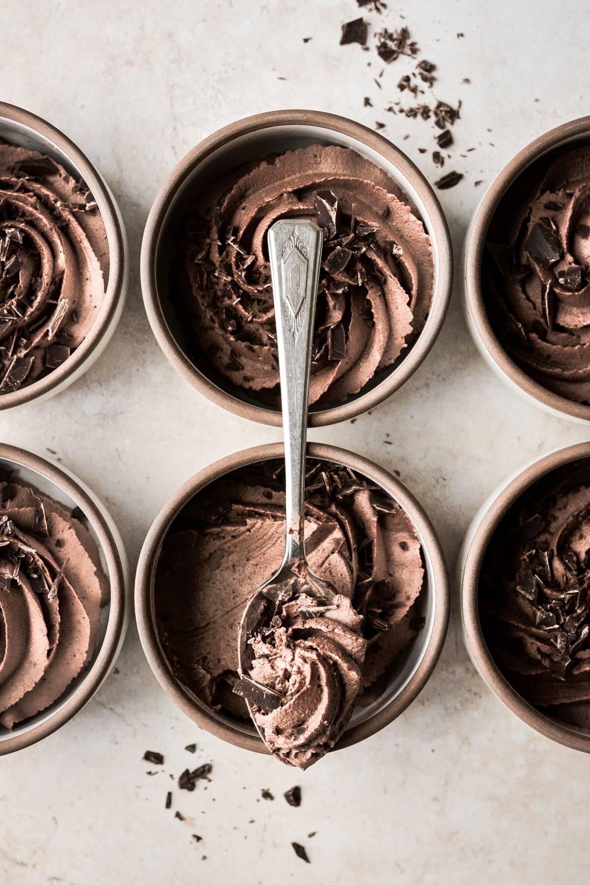 Spoonful of chocolate espresso mousse resting on a ramekin.