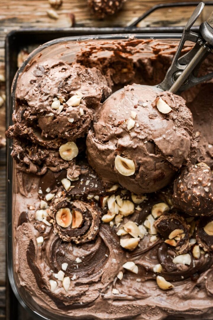 Scoops of chocolate hazelnut ice cream sprinkled with hazelnuts.