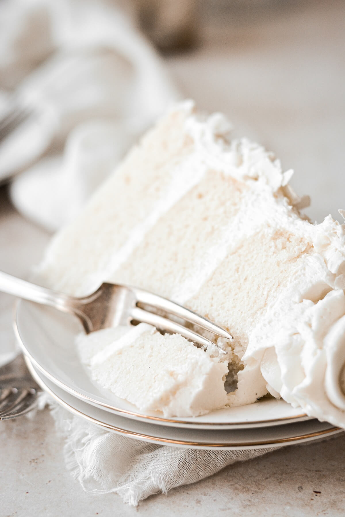 Slice of coconut cake with a bite taken.