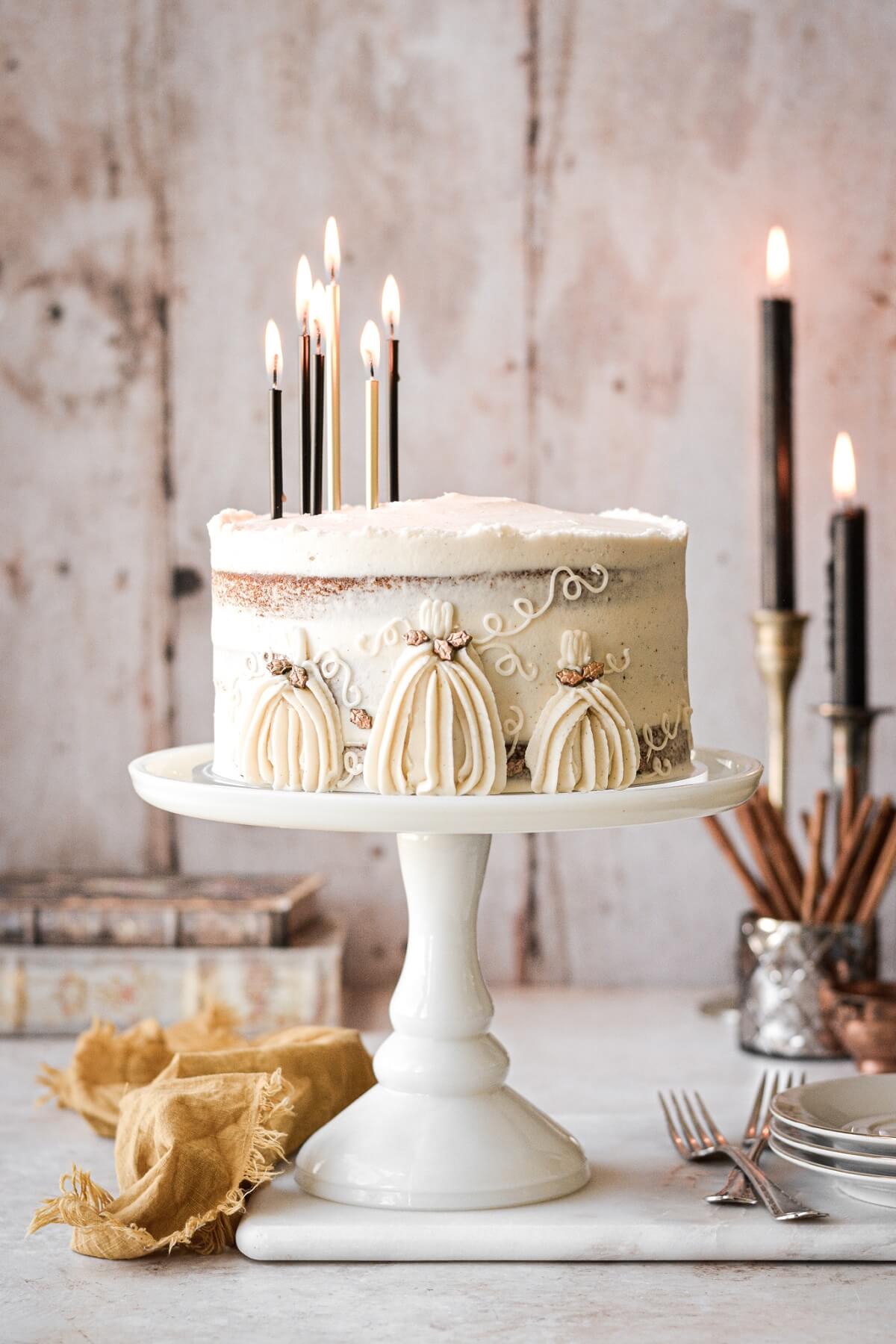 Pumpkin cake with buttercream pumpkins and black and gold birthday candles.