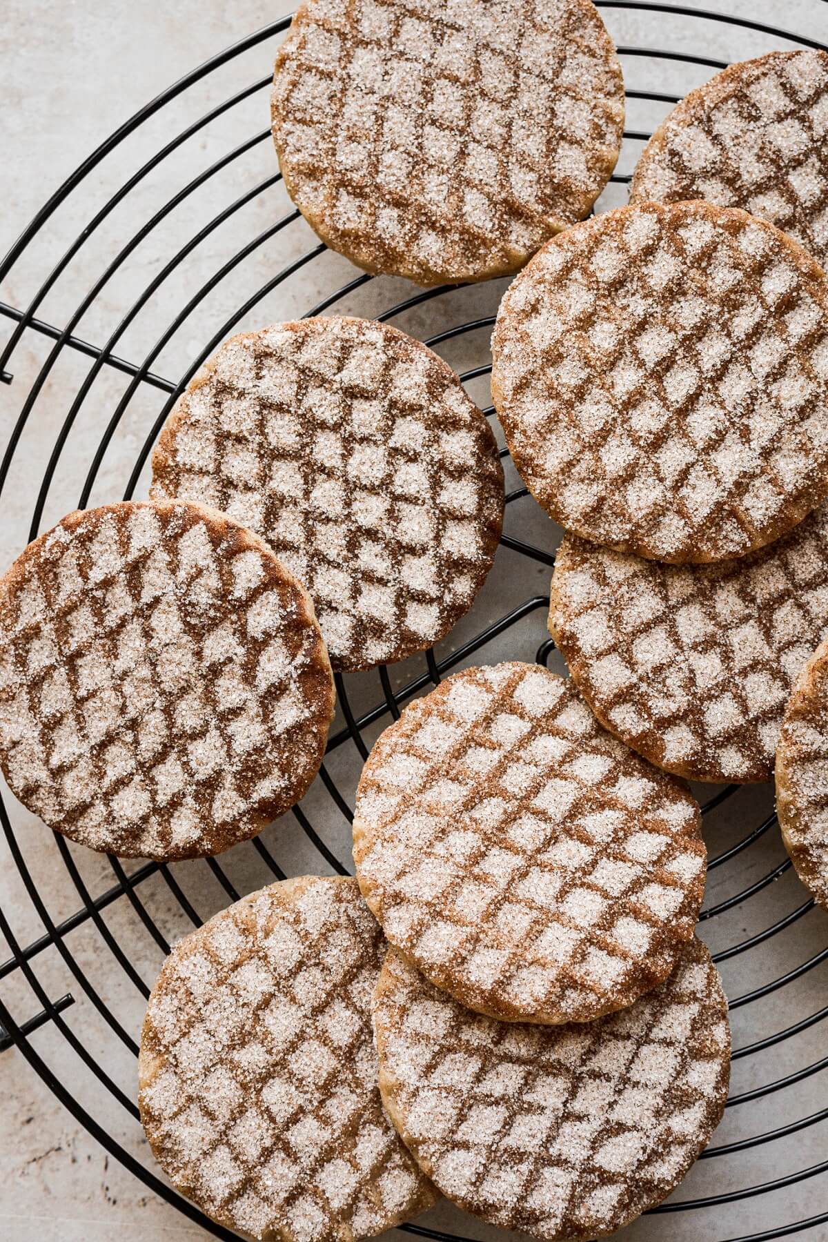 Stamped snickerdoodle shortbread cookies on a cooling rack.
