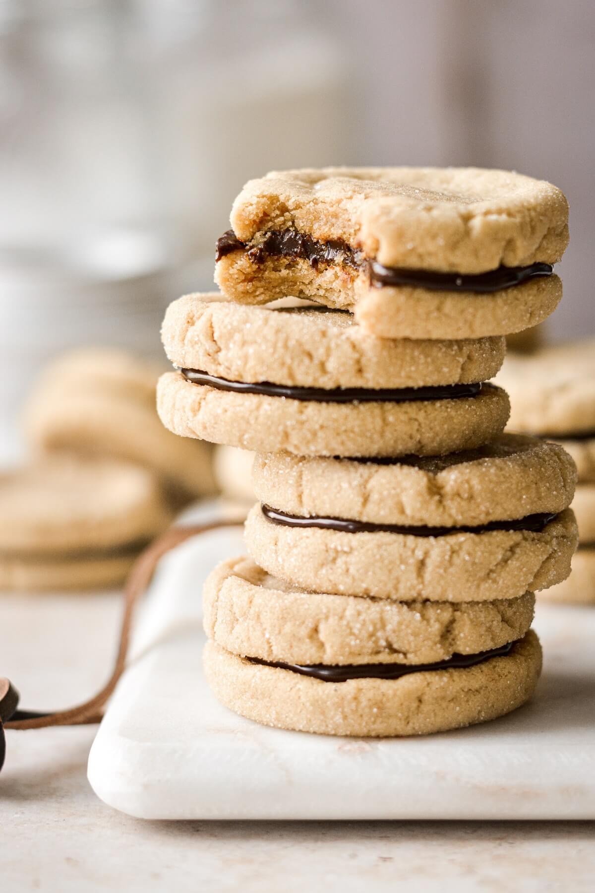 Stack of butterscotch sandwich cookies, one with a bite taken.