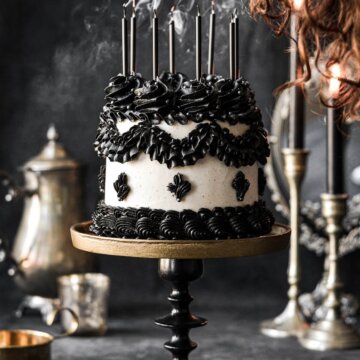 Candles being blown out on a black and white Lambeth cake.