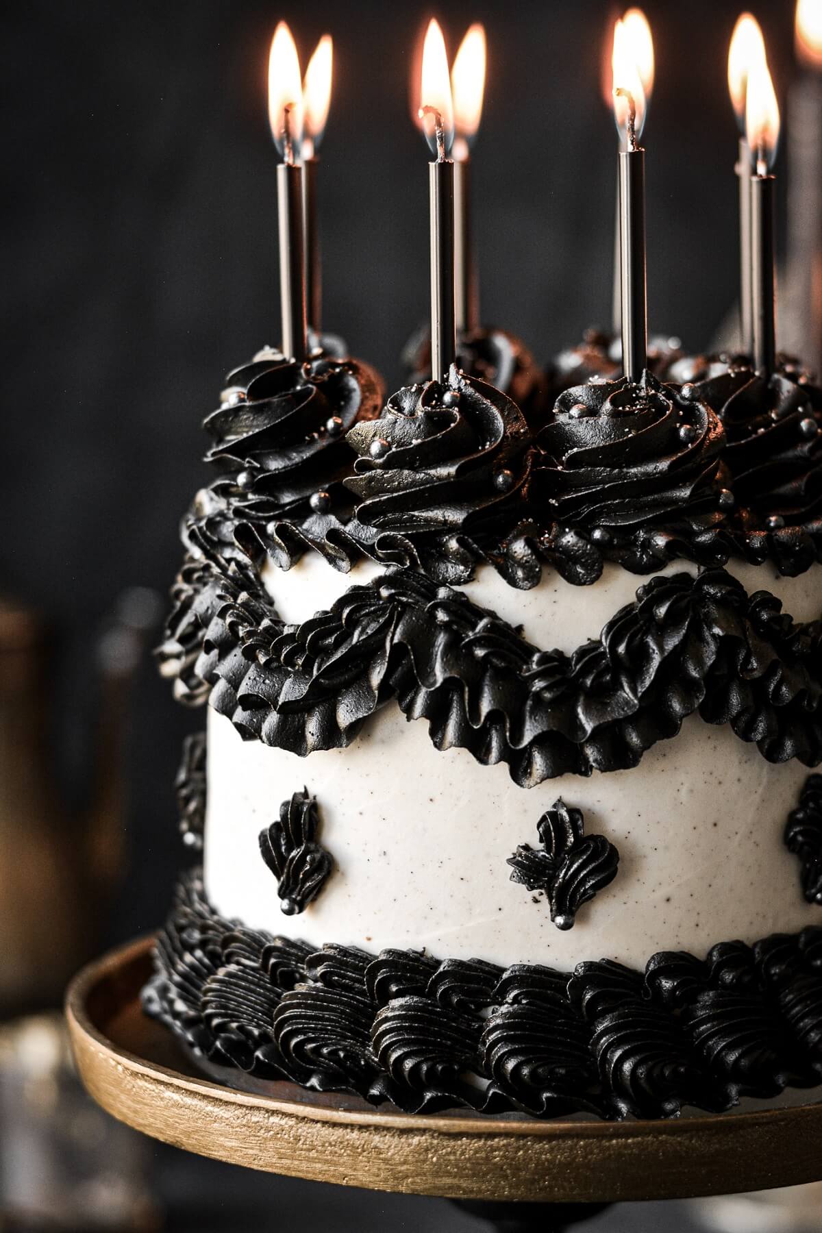 A gothic black and white cake with ruffled buttercream piping.