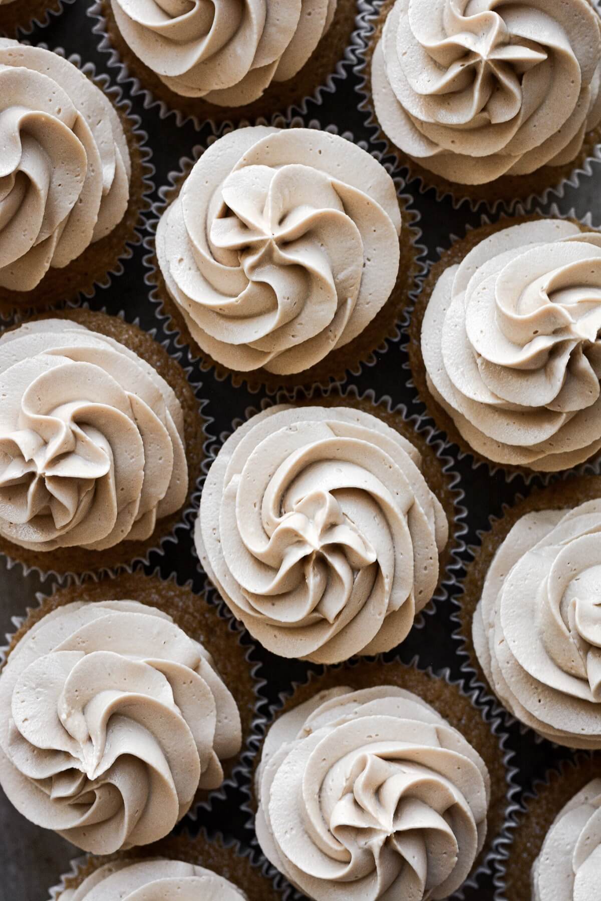 Coffee buttercream piped onto cupcakes.