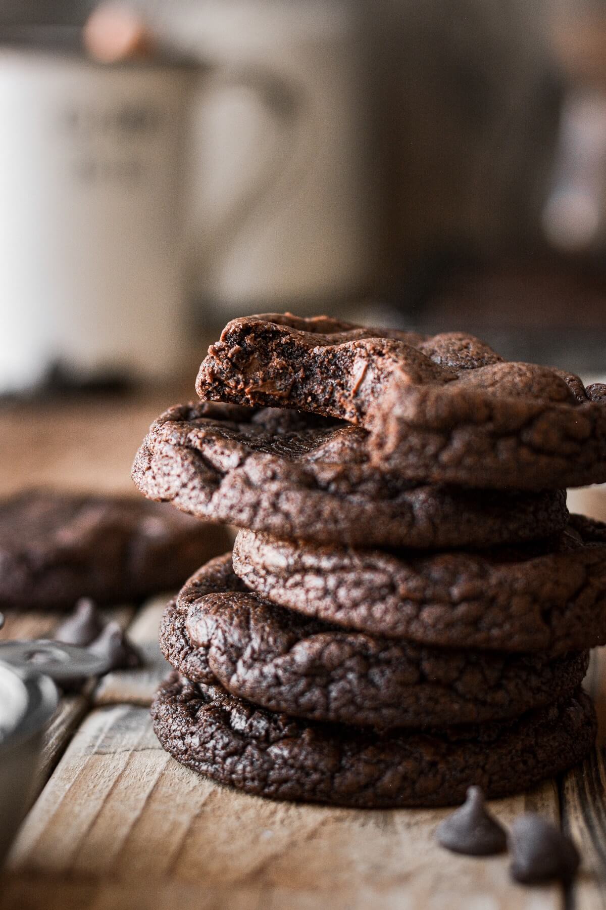Stack of chocolate brownie cookies, one with a bite taken.