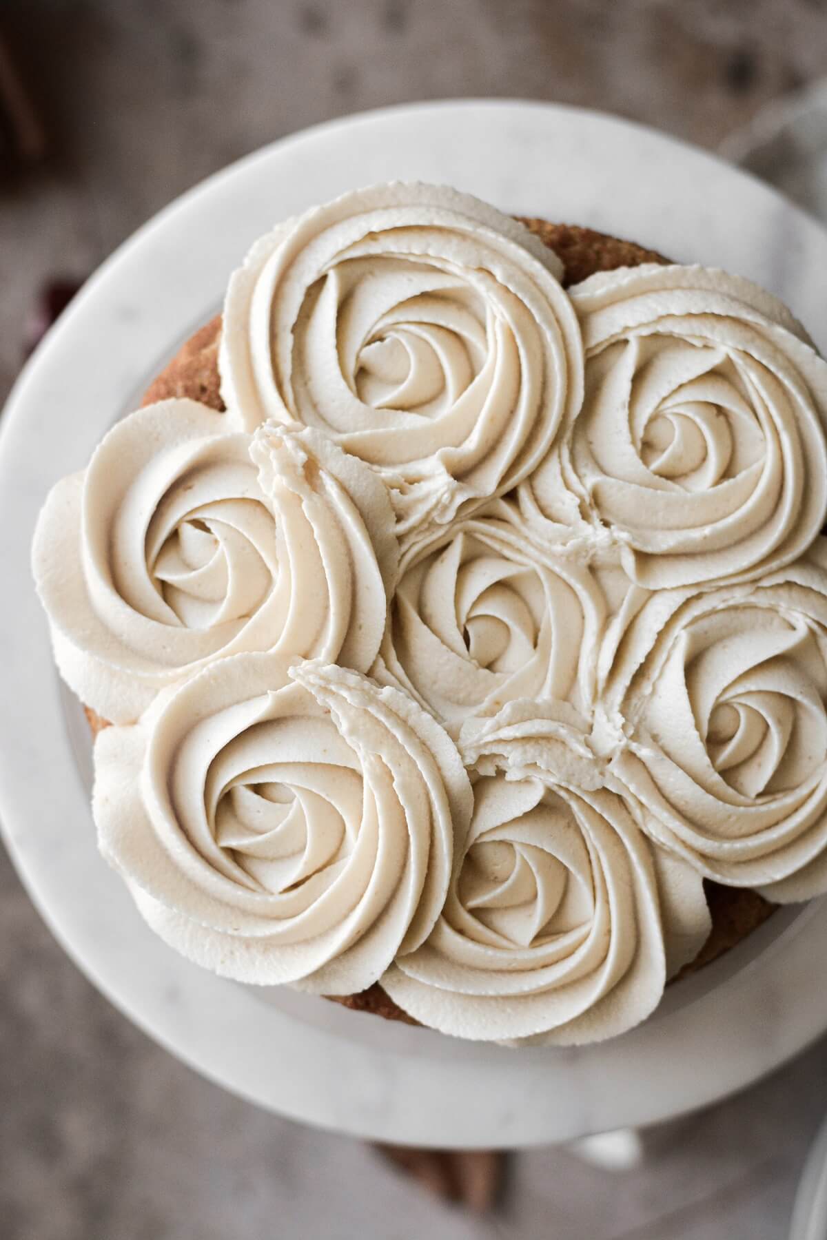 Maple frosting piped in rosettes onto maple walnut cake.