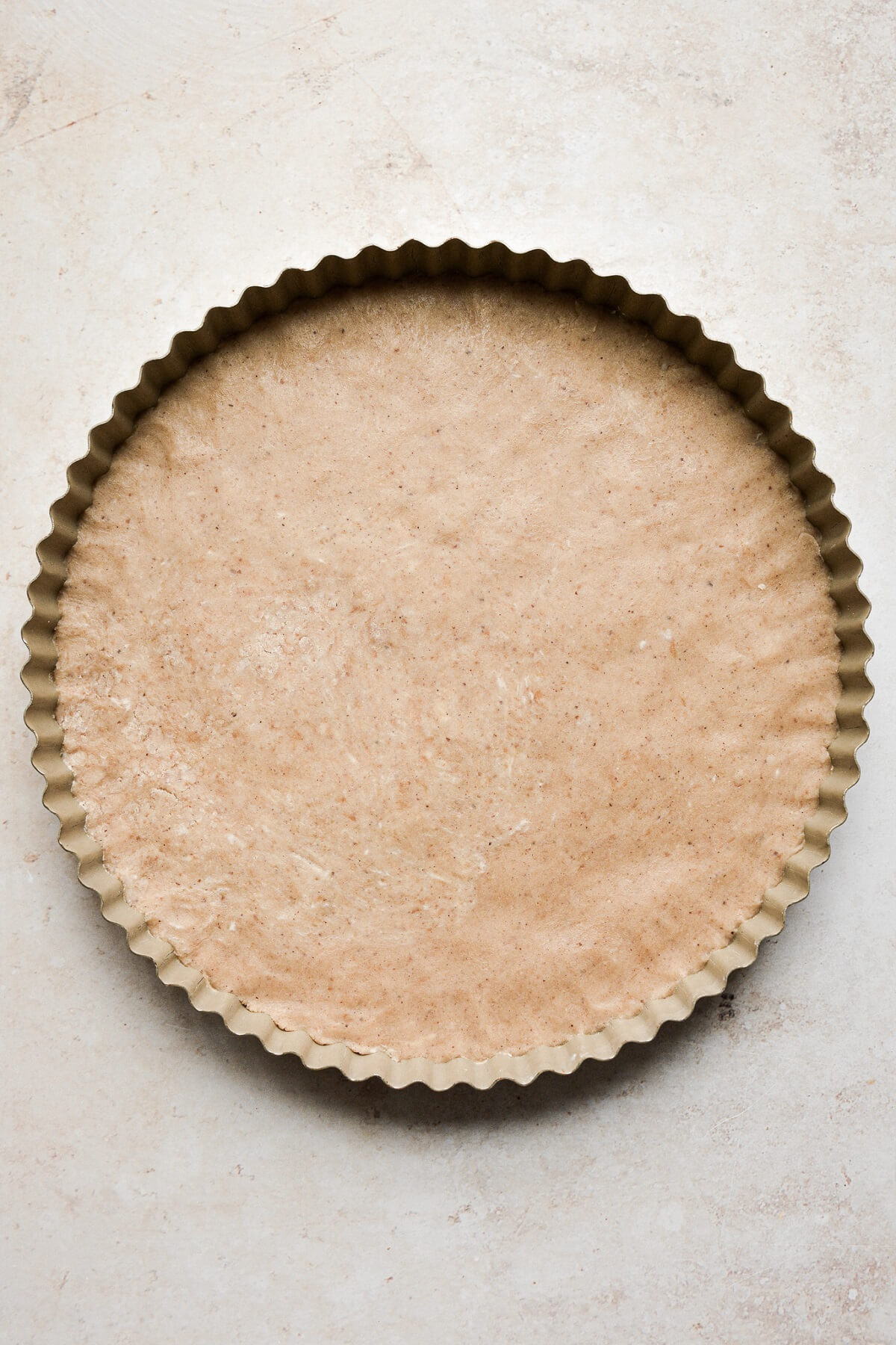 Shortbread dough pressed into a tart pan.