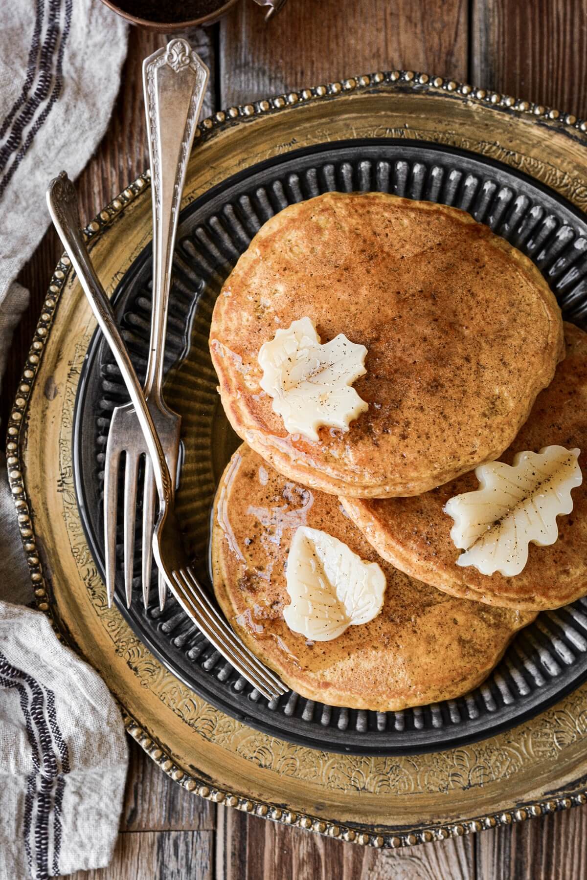 Three pumpkin pancakes with butter leaves.