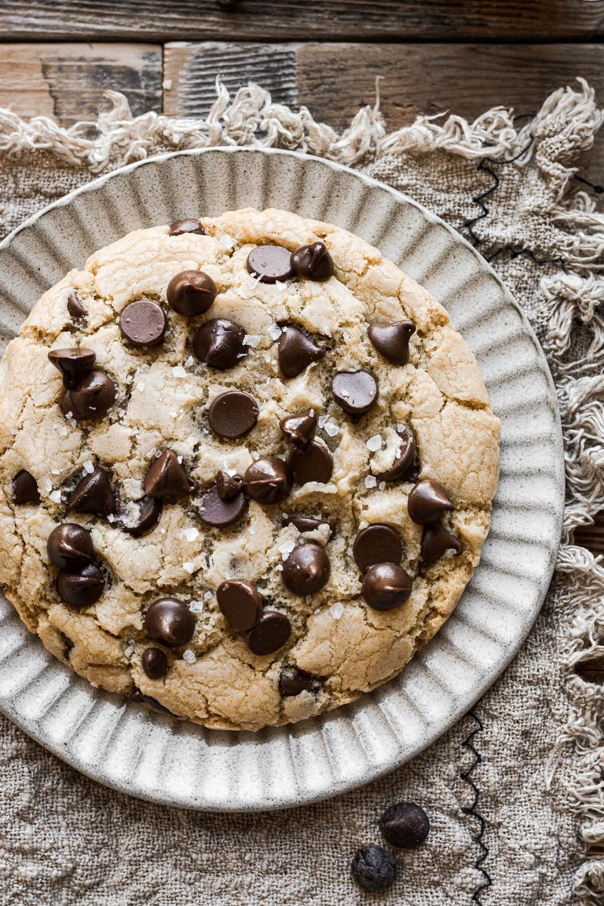 A big chocolate chip cookie on a plate.