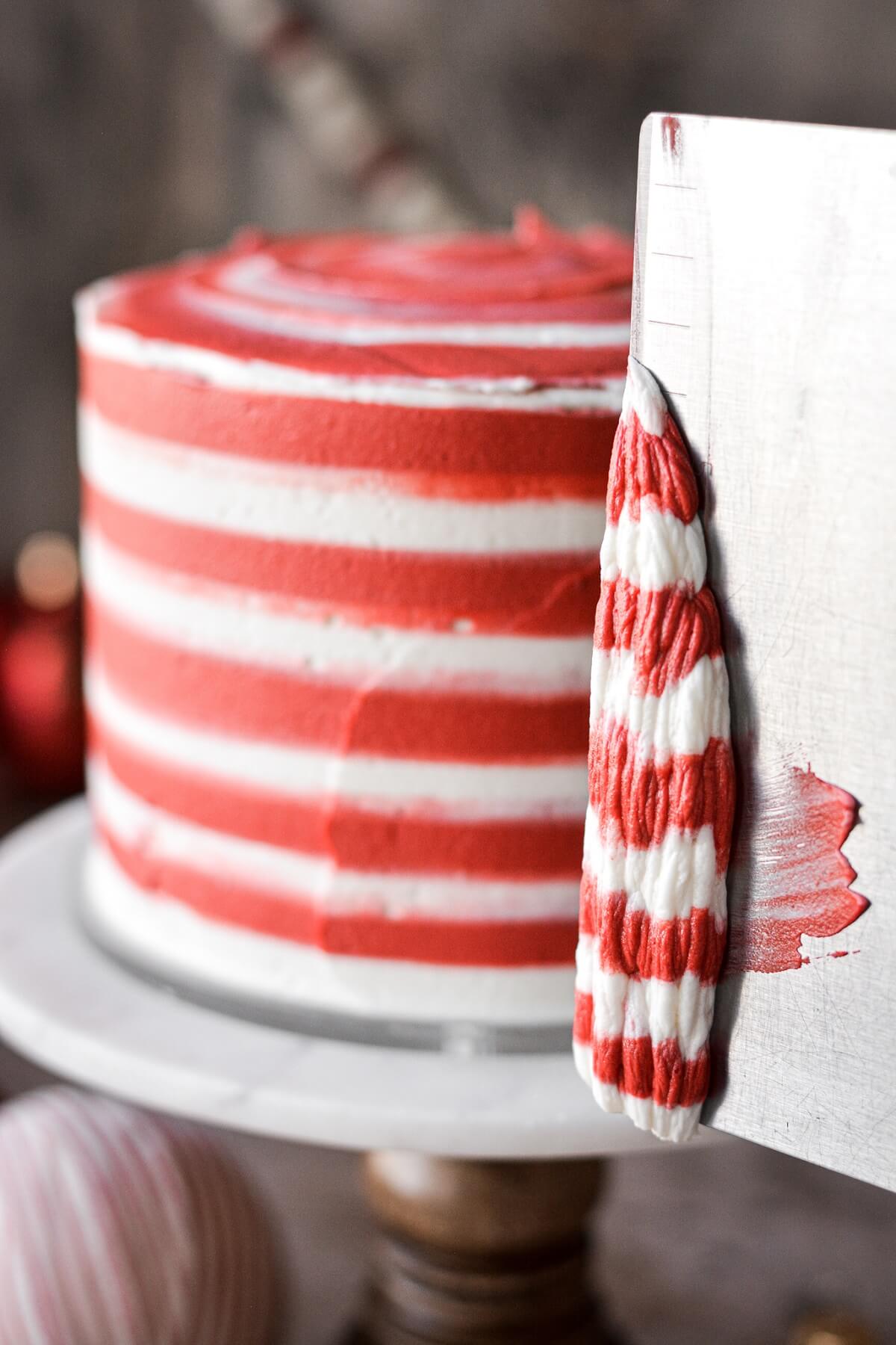 Step 5 for frosting a cake with red and white striped buttercream.