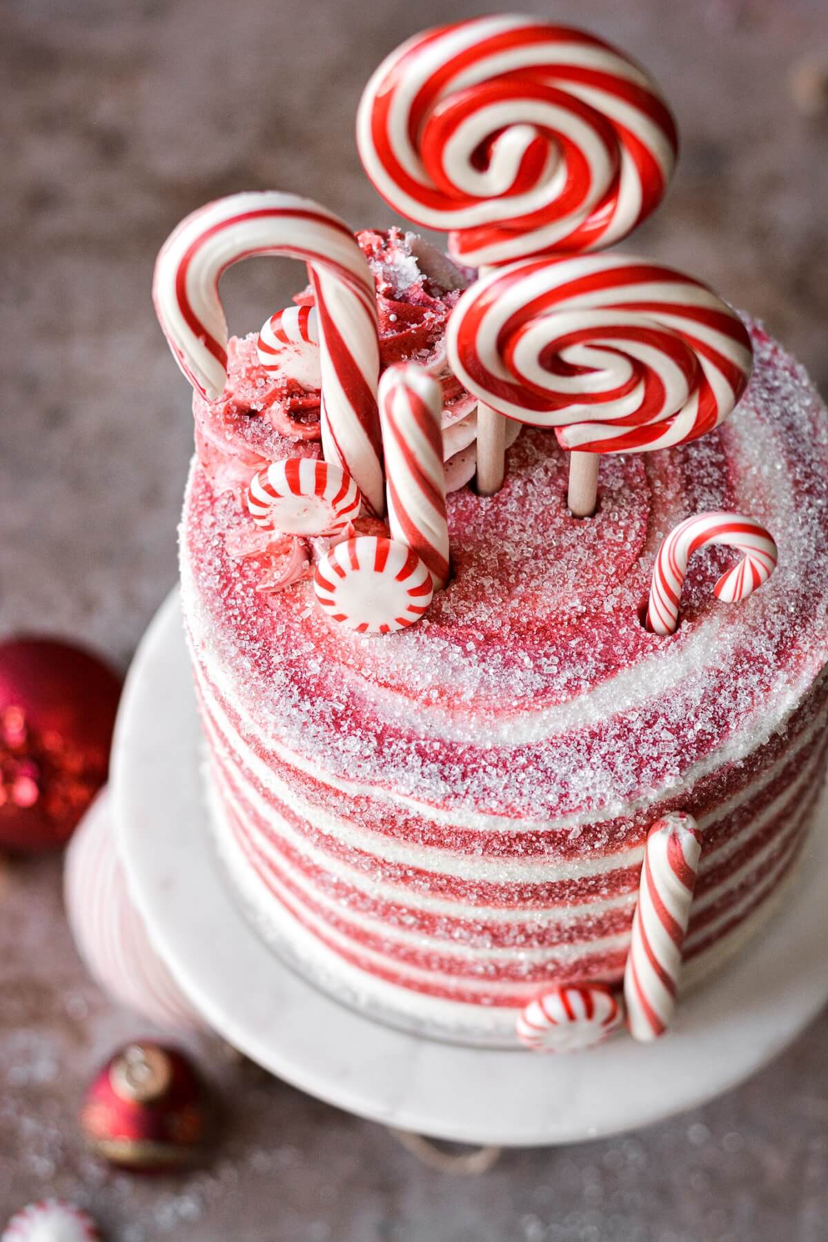 Peppermints and candy canes on top of a candy cane cake.