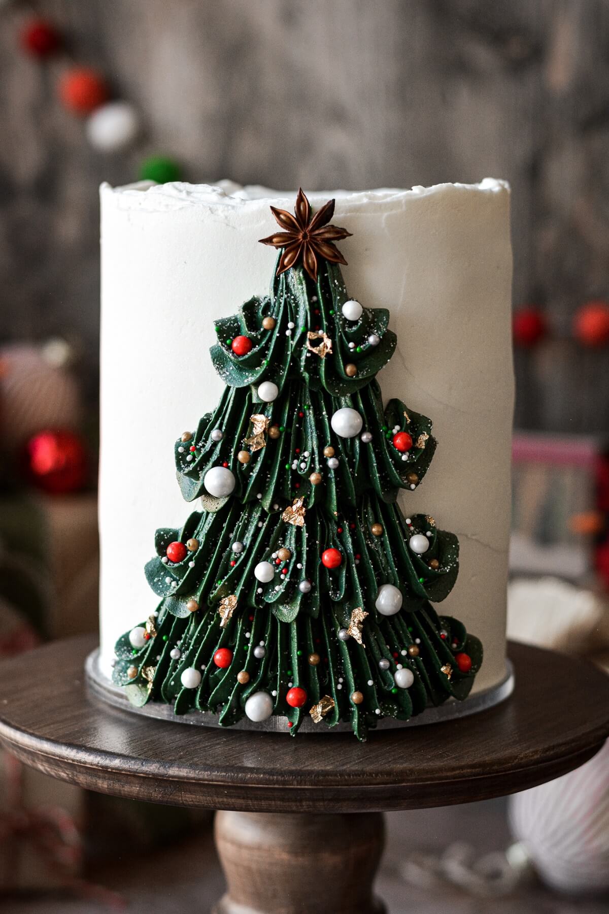 Buttercream Christmas tree piped onto a cake and decorated with sprinkle ornaments.