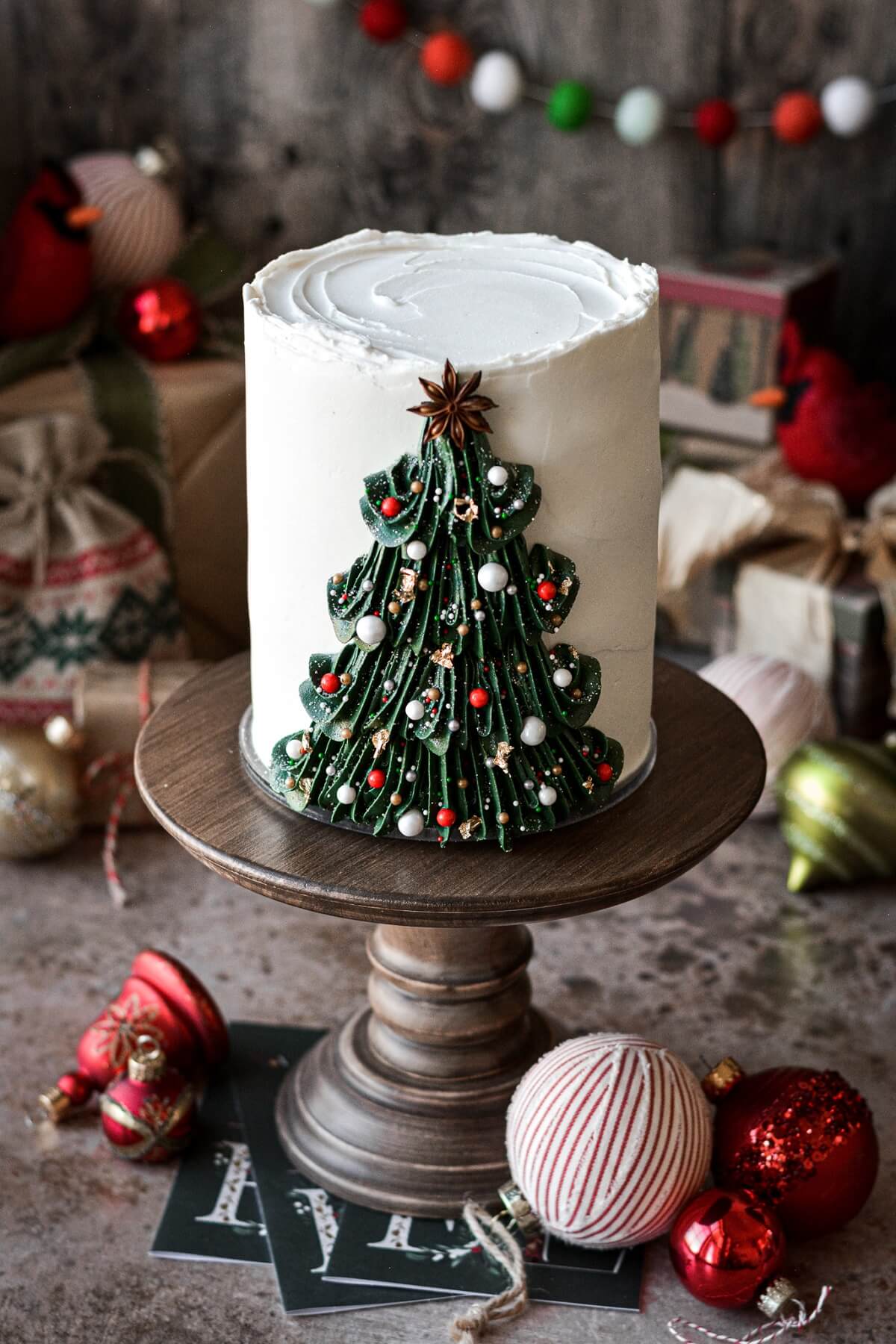 Buttercream Christmas tree cake on a wooden cake stand.