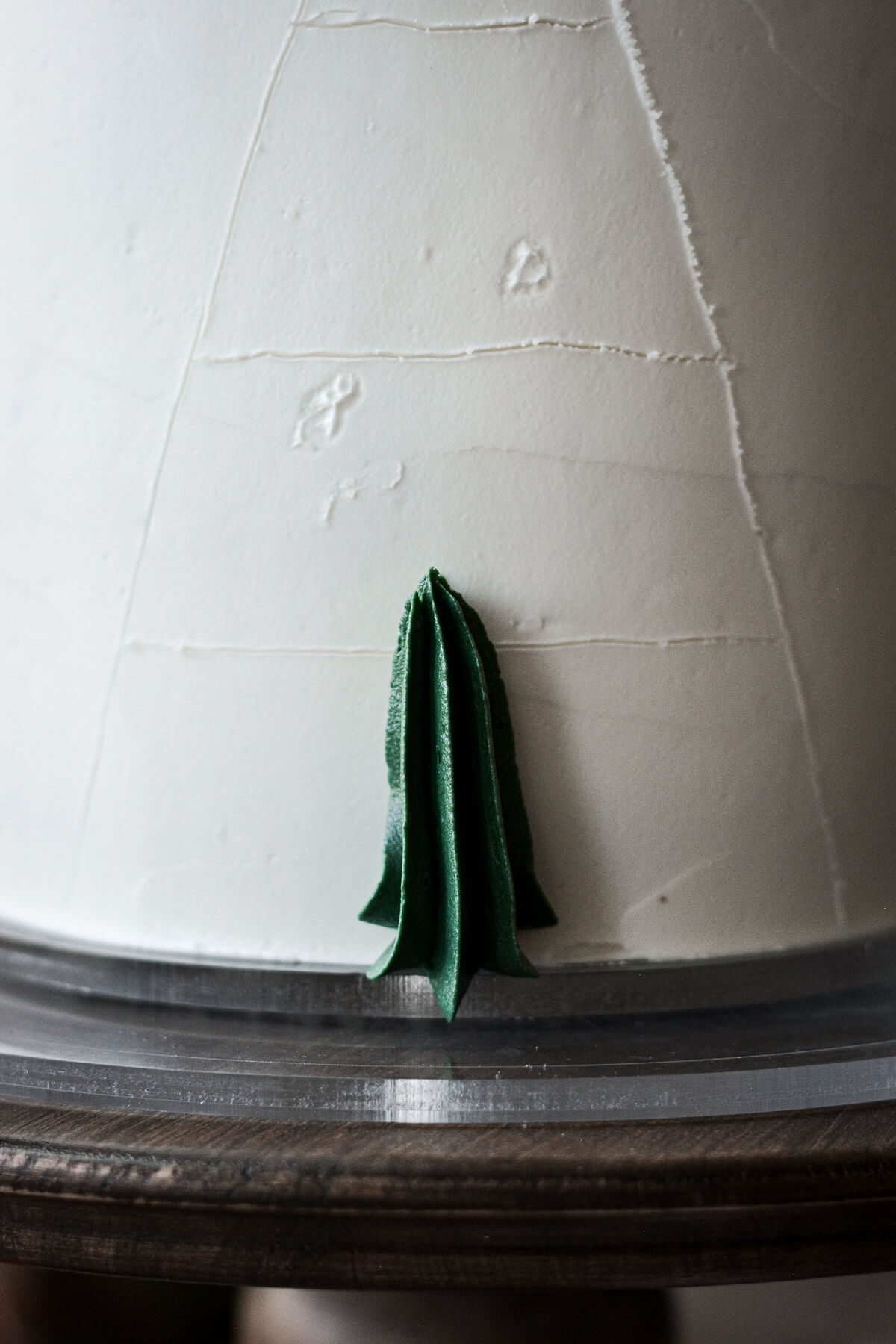 Step 3 for decorating a buttercream Christmas tree cake.