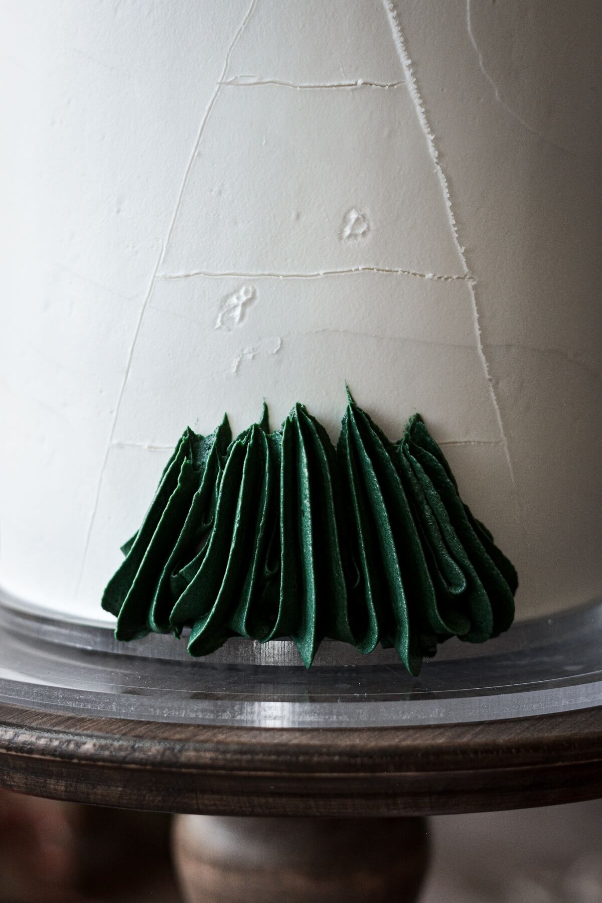 Step 4 for decorating a buttercream Christmas tree cake.