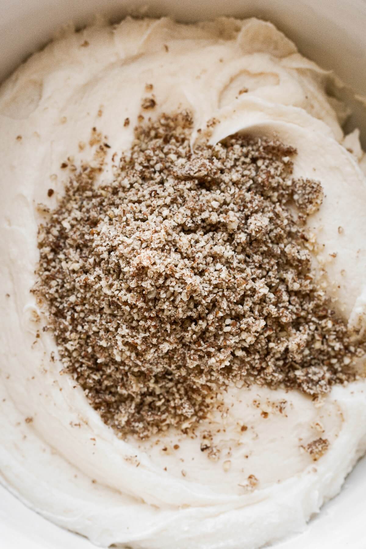 Pecans being stirred into buttercream.