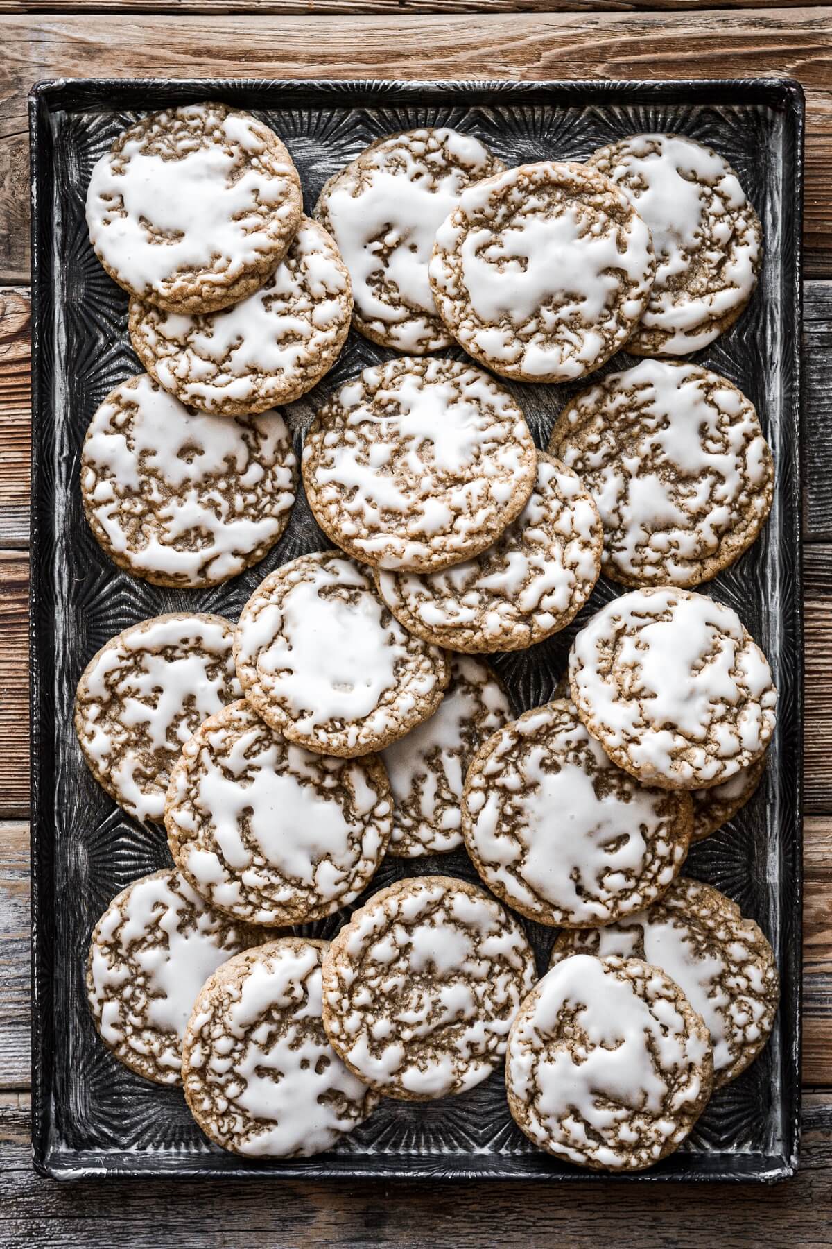Baking sheet full of old fashioned iced oatmeal cookies.