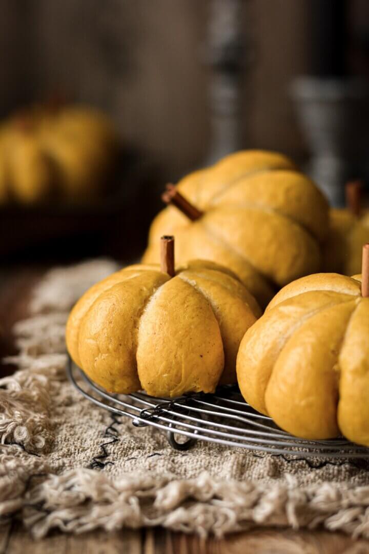 Pumpkin shaped dinner rolls with cinnamon stick stems.