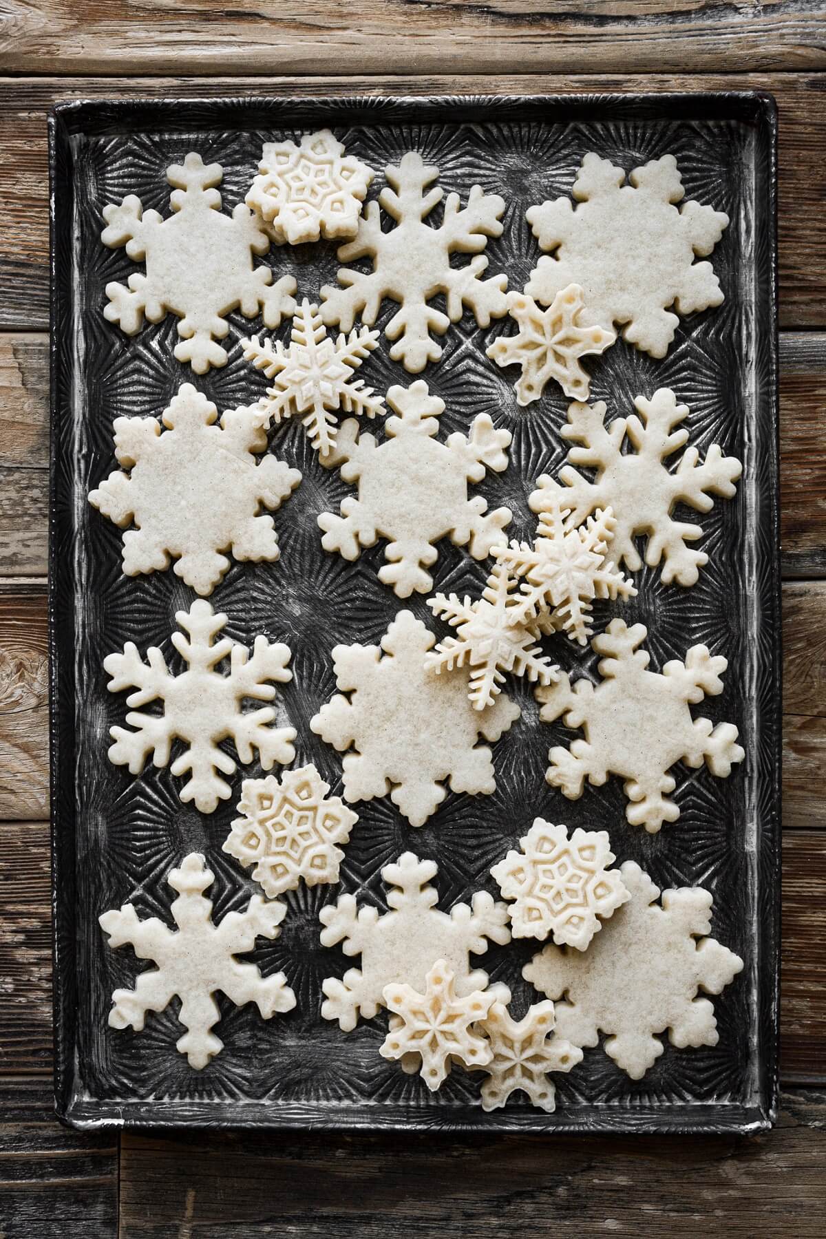 Snowflake cookies on a baking sheet.