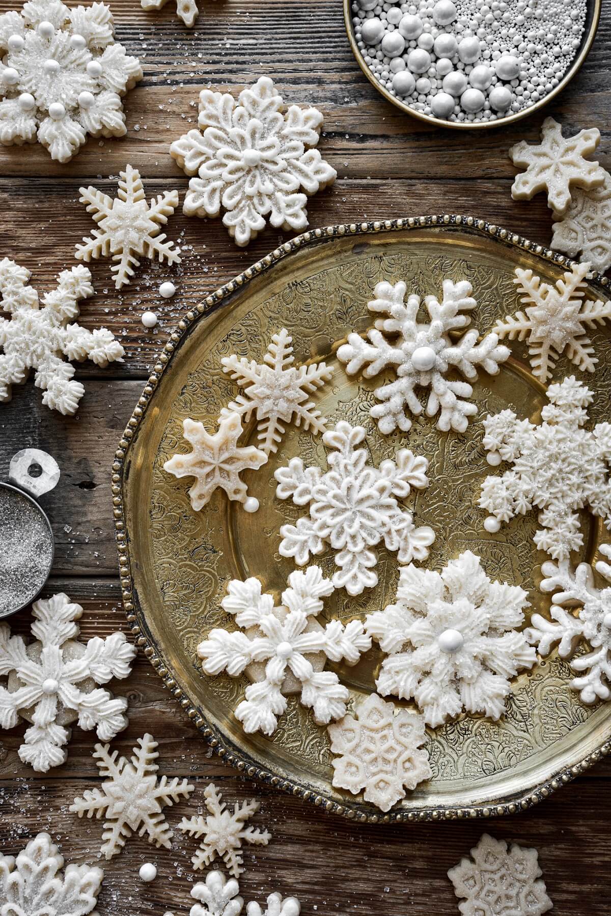 Snowflake sugar cookies on a gold plate.