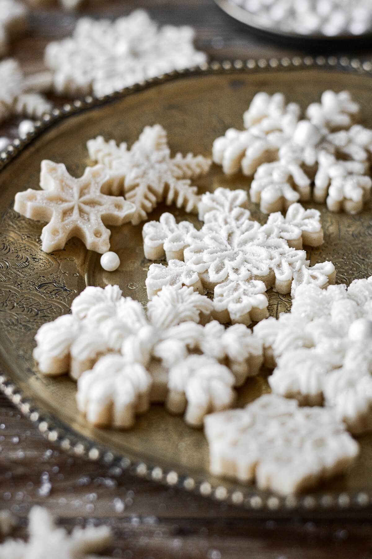 Buttercream frosting piped onto snowflake cookies.