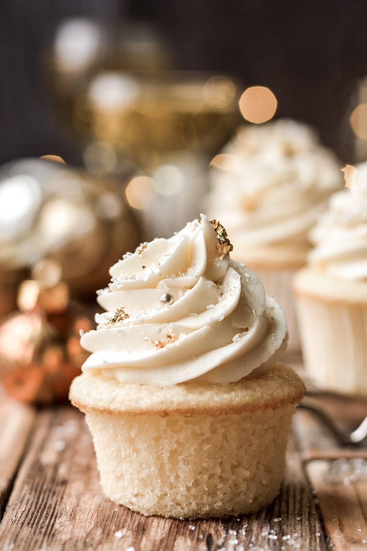 Champagne cupcake with gold sugar pearls and sparkling sugar.
