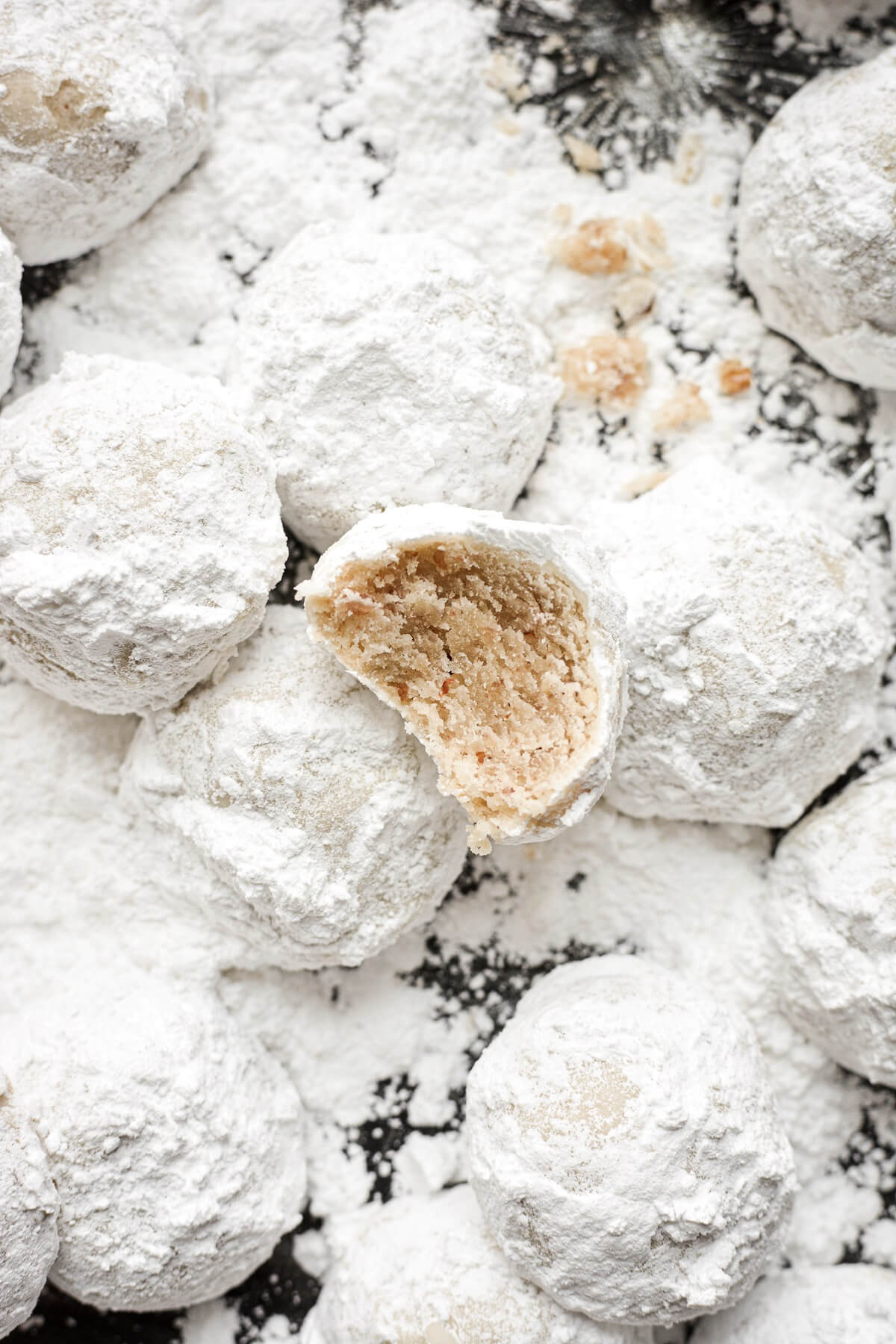 Snowball cookies, one with a bite taken.