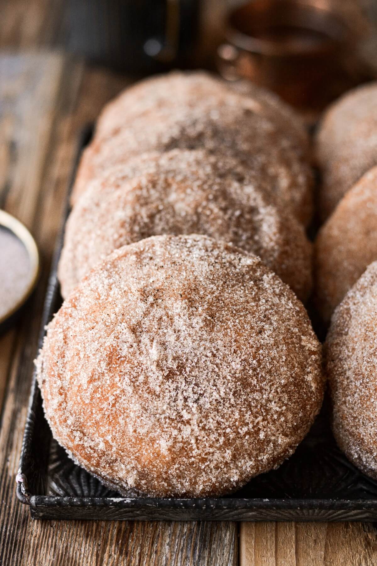 Mini fried apple pies covered in cinnamon sugar.